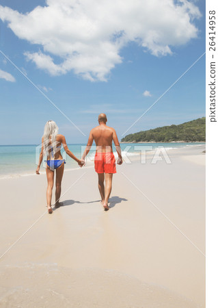 Pretty couple walking on a tropic beach 26414958