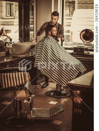 Confident man visiting hairstylist in barber shop. 26419019