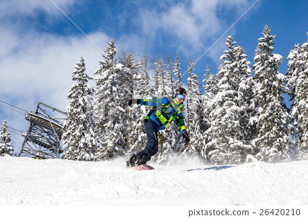 Professional snowboarder going down the slopes  26420210