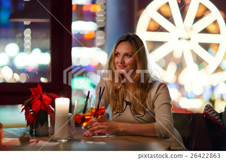 Young woman drining cocktail in restaurant Young woman drining cocktail in restaurant 26422863