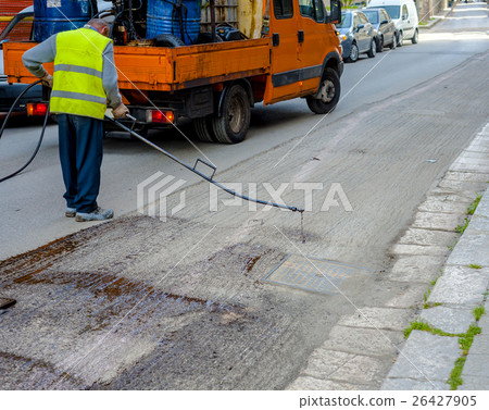 Road worker spraying bitumen emulsion Road worker spraying bitumen emulsion 26427905