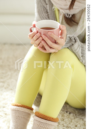 A woman drinking a hot drink A woman drinking a hot drink 26430082