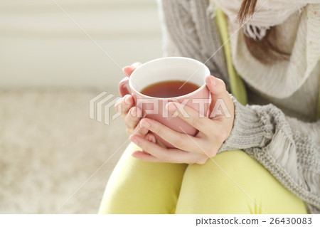A woman drinking a hot drink 26430083