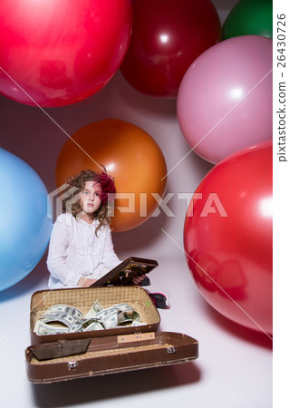 Girl schoolgirl with wooden abacus and lying in a suitcase with  26430726