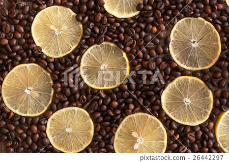 Lemon slices lying among the coffee bean on a 26442297
