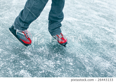 A child with a stick on the ice skating in the win 26443133