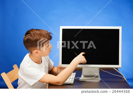 School-age boy sitting with the monitor laptop at 26444388