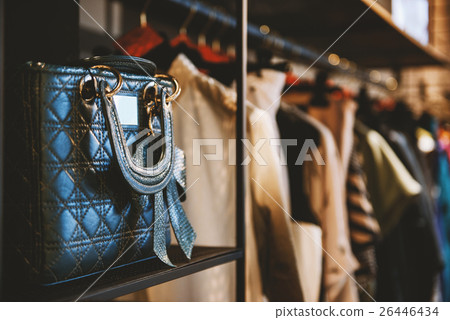 Handbags and clothes in a fashion store 26446434