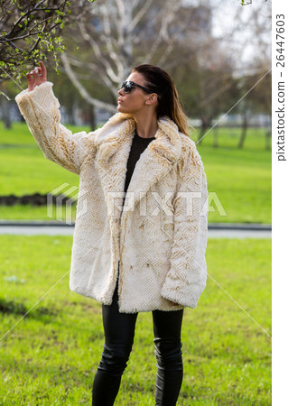 Woman touches a branch in sunglasses and fur coat 26447603