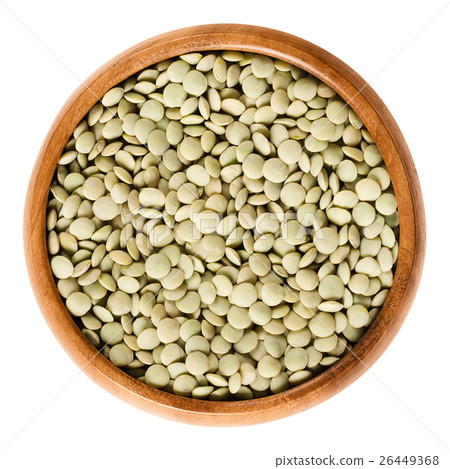Green lentils in wooden bowl over white 26449368