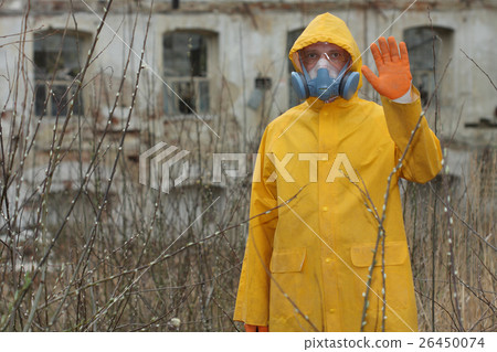 Man with protective mask explores danger area. 26450074