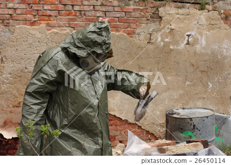 Man with gas mask explores dead bird Man with gas mask explores dead bird 26450114