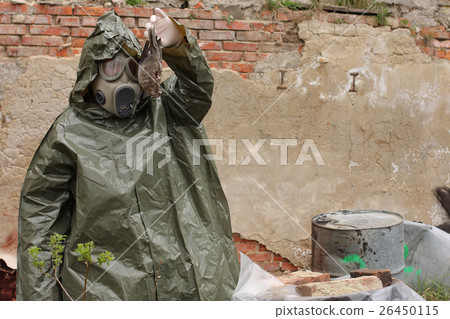 Man with gas mask  explores dead bird 26450115