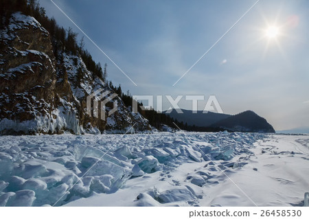 Sun over clumps of blue ice on the snow. Beautiful 26458530