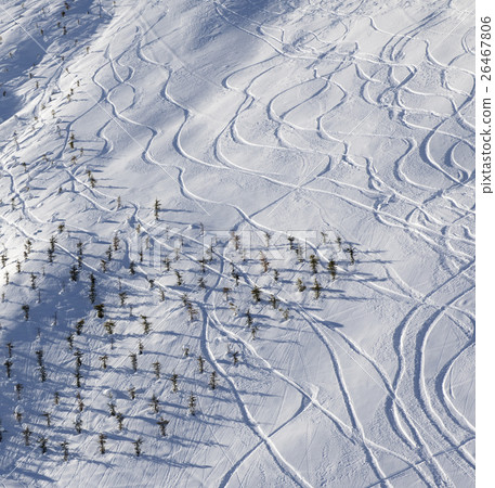 Off-piste slope with traces from ski and snowboard at sun mornin 26467806