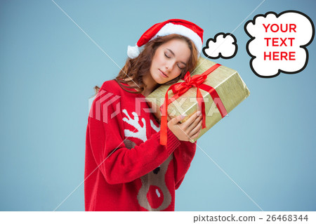 Girl dressed in santa hat with a Christmas gift Girl dressed in santa hat with a Christmas gift 26468344