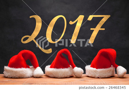 The three Santa red hats on wooden background The three Santa red hats on wooden background 26468345
