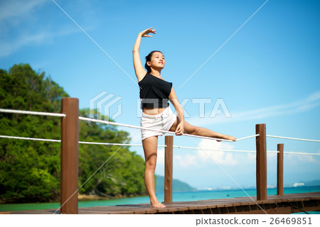 Asian girl doing Yoga pose at the pier Asian girl doing Yoga pose at the pier 26469851