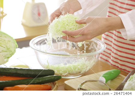 A woman exposing shredded cabbage cut with peeler to water 26471404