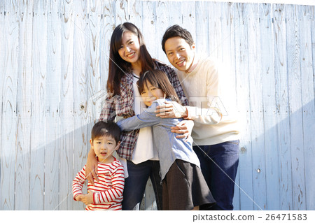 A family standing in front of a colored fence A family standing in front of a colored fence 26471583