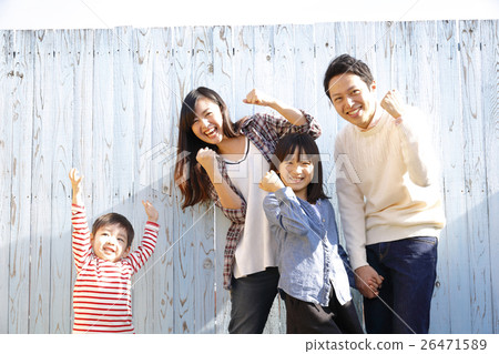 A family standing in front of a colored fence 26471589