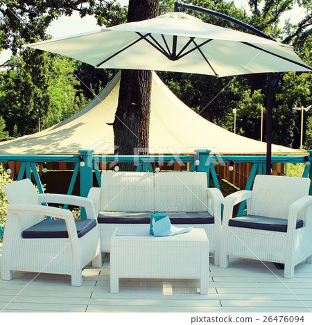 Al fresco cafe with white rattan wicker armchairs  26476094