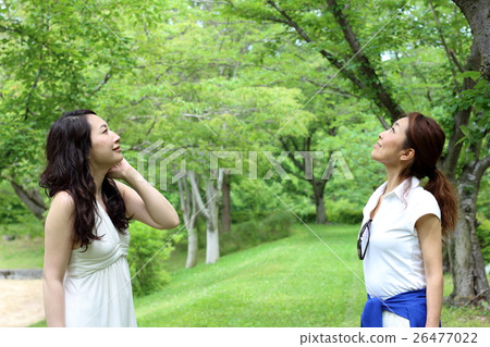 Two women looking at the center in the park 26477022