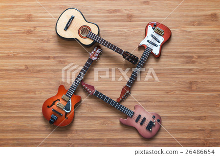 Set of four guitars on a wooden background. 26486654