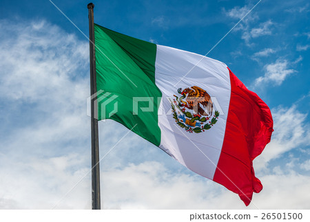 Flag of Mexico over blue cloudy sky 26501500