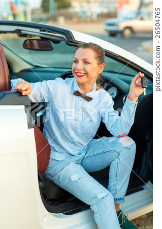 Woman sitting in a convertible car with the keys in hand Woman sitting in a convertible car with the keys in hand 26504765