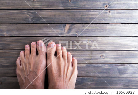 male feet on wooden background. 26509928