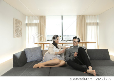 Male and female relaxing in the living room Male and female relaxing in the living room 26521709
