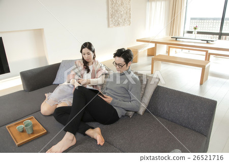 Male and female relaxing in the living room 26521716