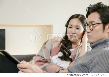 Male and female relaxing in the living room 26521762