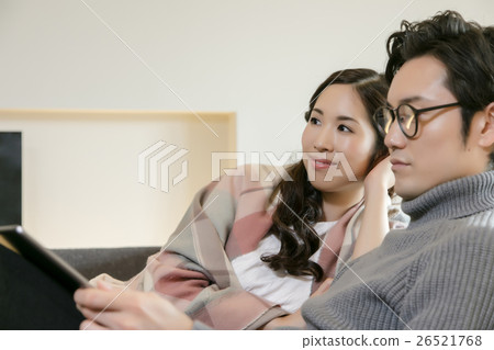 Male and female relaxing in the living room 26521768