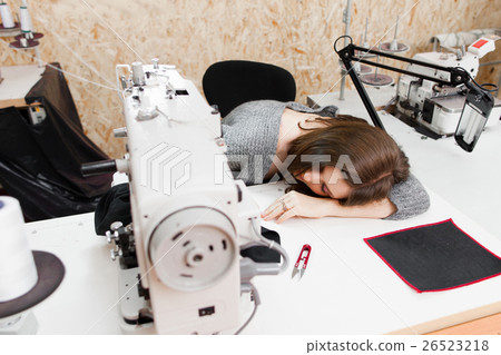 Young woman is asleep by her sewing machine 26523218