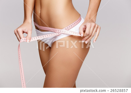Slim tanned woman's body over gray background 26528857