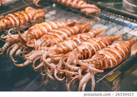 Squid on skewers is being grilled by street vendor Squid on skewers is being grilled by street vendor 26530423