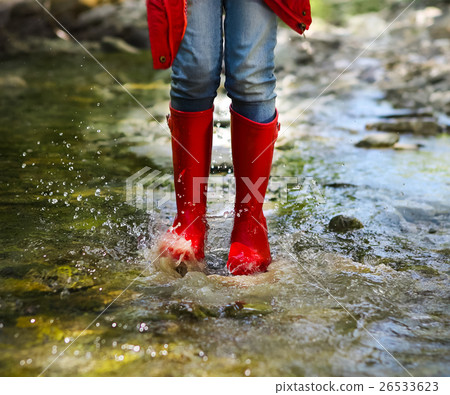 Child wearing red rain boots jumping. Close up Child wearing red rain boots jumping. Close up 26533623