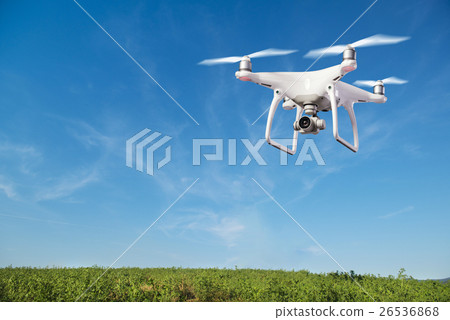 Hovering drone taking pictures of green hills 26536868