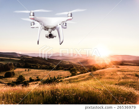 Hovering drone taking pictures of green nature at 26536979