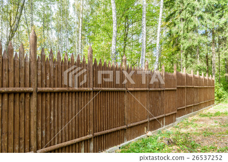 Fence made of vertical pointed logs in woodland Fence made of vertical pointed logs in woodland 26537252