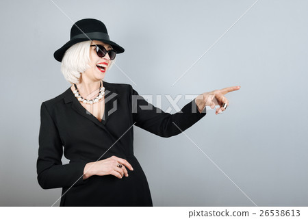 Laughing senior woman pointing on something. 26538613
