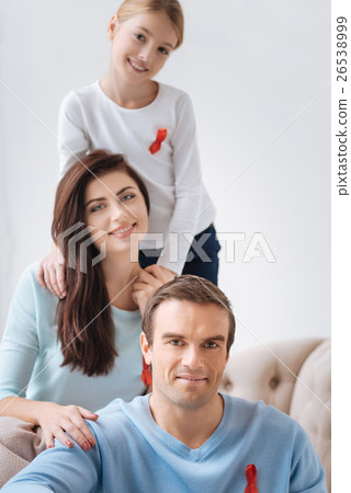 Happy pleasant family supporting AIDS prevention Happy pleasant family supporting AIDS prevention 26538999