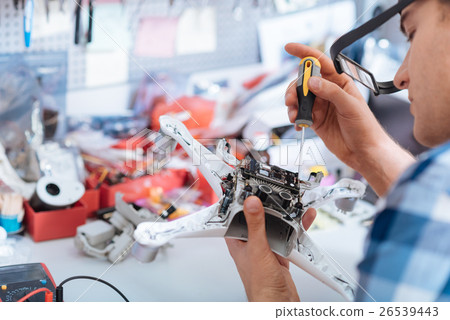 Concentrated man repairing drone detail with 26539443
