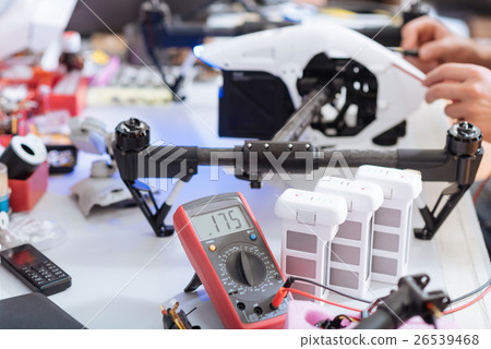 Close up of mans hands repairing drone and using 26539468