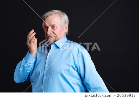 Very serious pensioner looking at camera 26539912