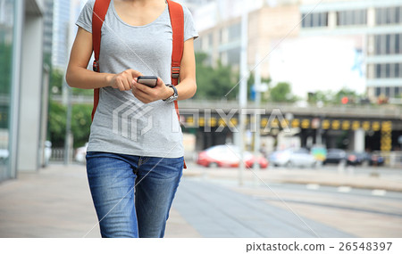 young woman walking with smart phone young woman walking with smart phone 26548397
