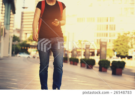 young woman walking with smart phone in city young woman walking with smart phone in city 26548783