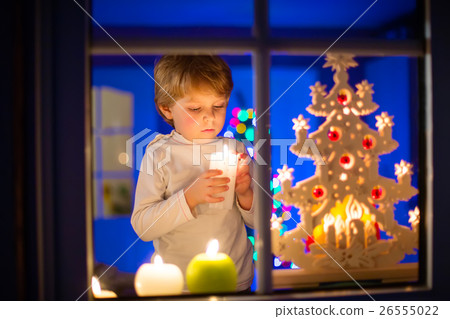 Little kid boy standing by window at Christmas 26555022